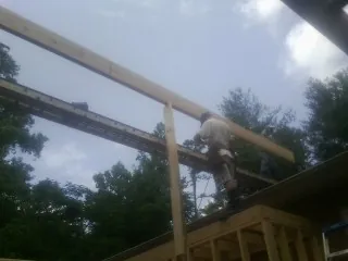 Carpenter setting a ridge beam over a new addition frame — Ice Dam Removal by Roofing Brothers in Lanham