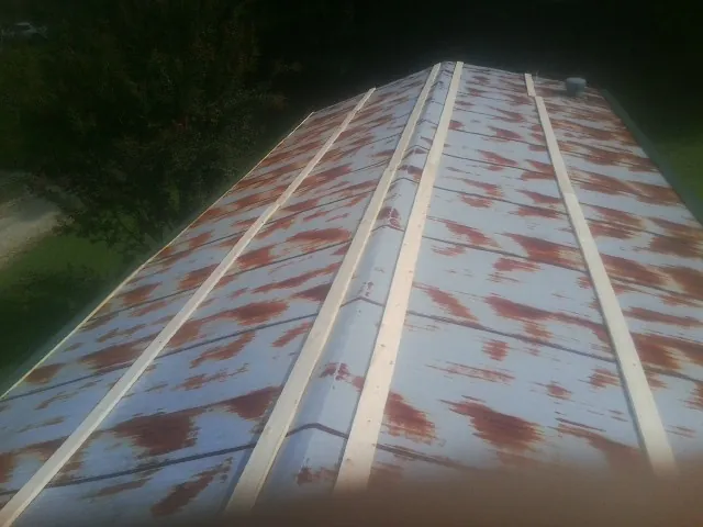 Rusted metal roof panels with new wood purlins before replacement — Storm Damage Roof Repair in Lanham by Roofing Brothers