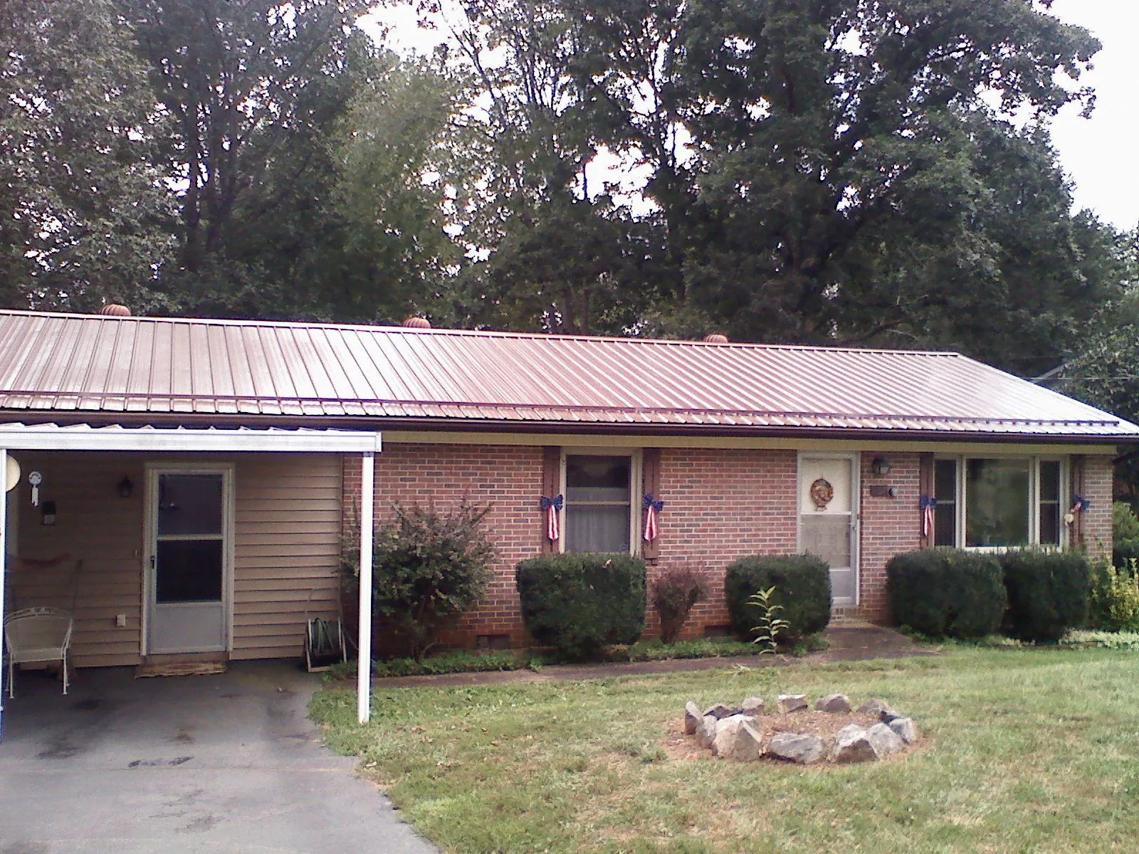 Bronze metal roof and carport on a brick ranch home — Roof Repair work by our crew in Lanham